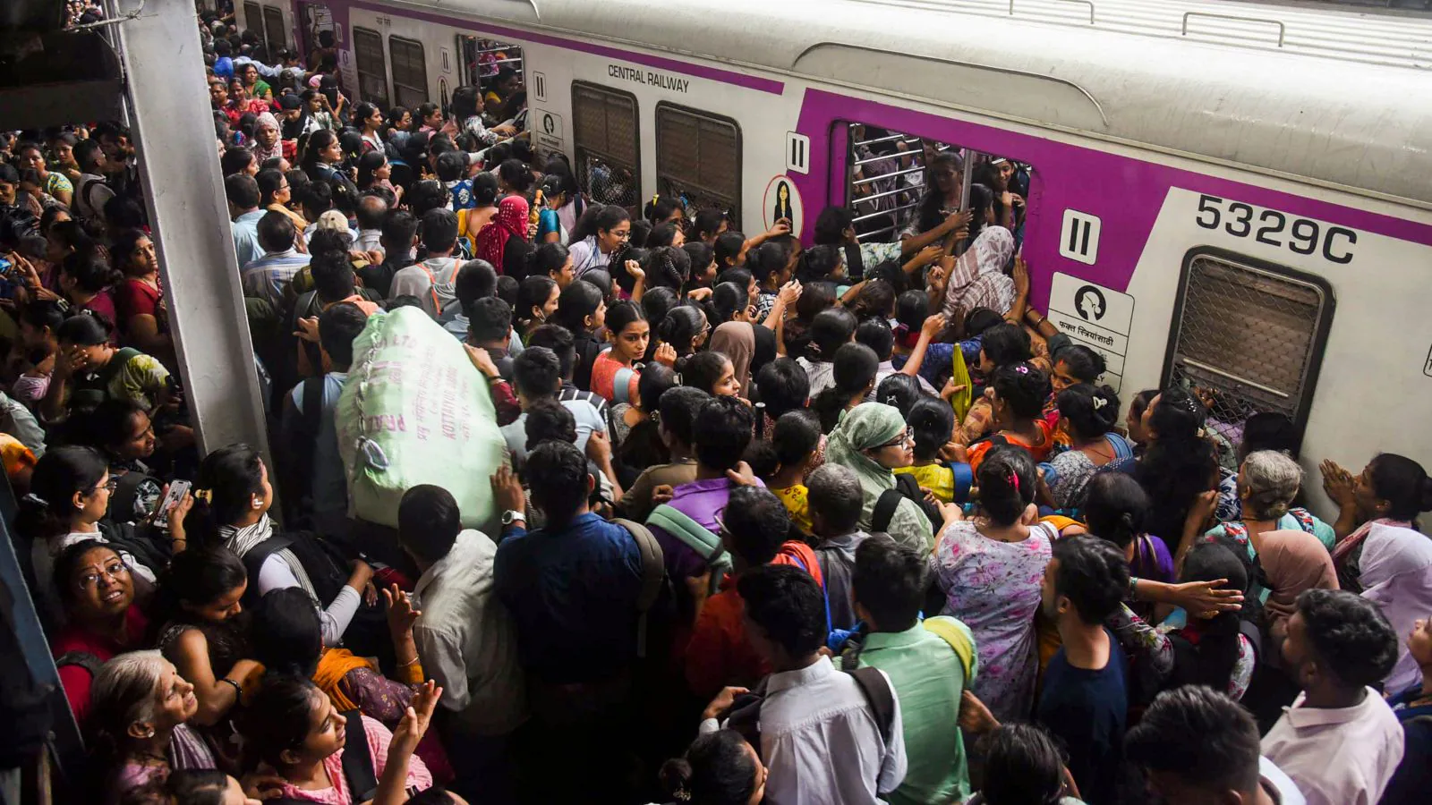 Mumbai local at peak hour - crowd rushing toward train doors